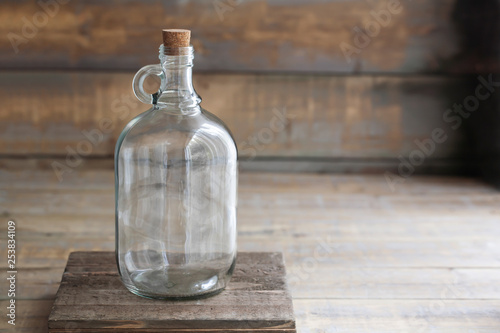 Download Mockup Of A Large Empty Growler Bottle On A Brown Wooden Table Stock Photo Adobe Stock
