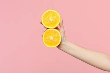 close up cropped photo of female hold in hand two fresh ripe halfs orange fruit isolated on pink pas