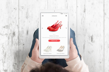 Tablet in woman hands with shopping ecommerce app with modern flat interface on display.