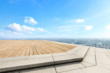 Empty wooden board square and modern city skyline with beautiful clouds