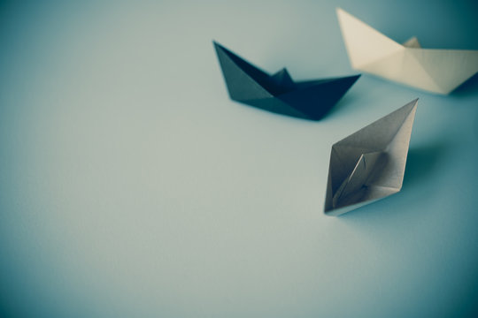 gray tone paper boat on clean background with copy space, journey and obstacle concept