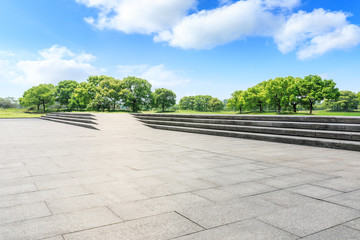 Empty square floor and green forest in the city park