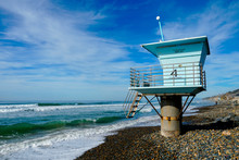 Blue Lifeguard Tower On A Rocky Sand Beach With Clouded Blue Sky Sunny End Of Day, On Torrey Pines State Beach In California, Located In San Diego County.