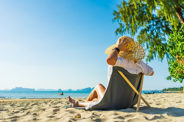 Woman enjoying her holidays on a transat at the tropical beach