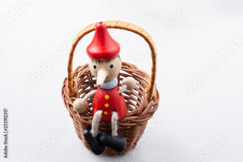 Pinochio toy figurine sitting in a basket