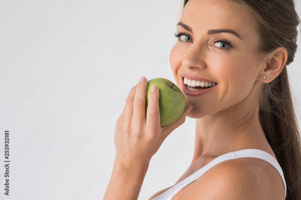 Woman biting green apple - obrazy, fototapety, plakaty 