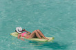© travnikovstudio - Woman relaxing on inflatable air mattress at turquoise water
