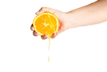 Female Hand Crushes Orange On White Background