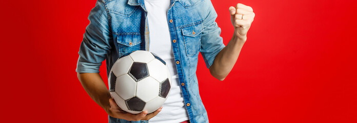 Handsome man holding a soccer ball over colorful backgound