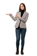 © luismolinero - A full-length shot of a Young business woman holding copyspace imaginary on the palm to insert an ad over isolated white background