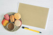 Empty page of brown paper and sweet dessert macaroon on white background.