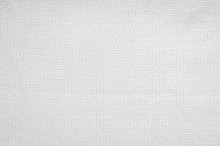 White knitted fabric background. The texture of the white wool fabric. 