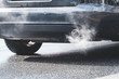exhaust gas coming out of an exhaust pipe of a car on a street
