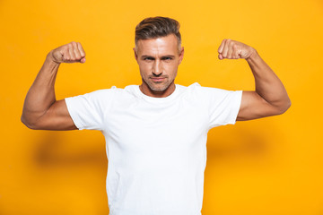 Sticker - Image of european man 30s in white t-shirt raising hands and showing biceps