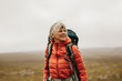© Jacob Lund - Female hiker enjoying the view standing on a hill