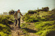 © Jacob Lund - Man trekking up a hill using hiking poles
