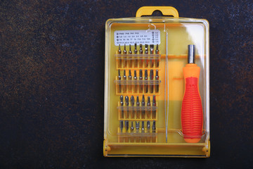 screwdriver with a set of nozzles on a vintage background