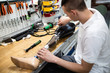 Disabled man working in amputee shop for production prosthetic extremity parts.