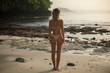 © South House Studio - back shot of slim young model in pink laced top and bikini on ocean sand beach