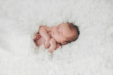 Wall Mural - naked newborn baby sleeping curled up in a ball