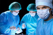 © rogerphoto - Group of surgeons in masks performing operation. Medicine, surgery and emergency help concepts