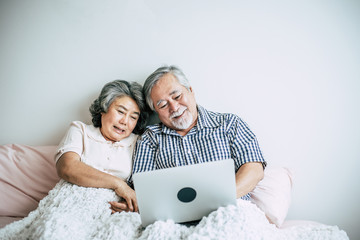 Wall Mural - Elderly couples talking and using laptop in bedroom