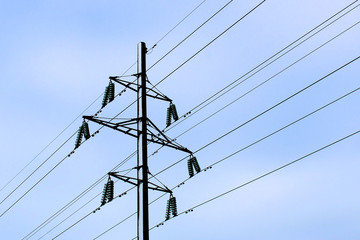 Power line pole with wires against a blue sky