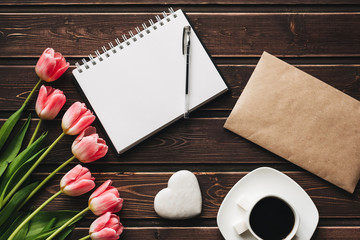 Wall Mural - bouquet of pink Tulip flowers and a Cup of coffee on a wooden brown table