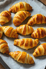 Homemade butter croissants on wooden background.