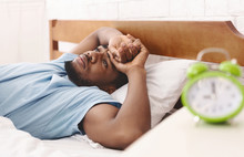 Black Man In Bed Suffering From Insomnia And Sleep Disorder