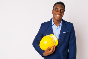 Portrait of young happy African businessman holding hardhat