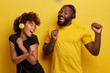 © wayhome.studio  - Cheerful young African American bloggers enjoy favourite playlist in headphones, listens audio in music app, feels happiness, dance actively against yellow background, move emotionally, have fun