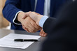 © rogerphoto - Business people shaking hands, finishing up a papers signing. Meeting, agreement and lawyer consulting concept