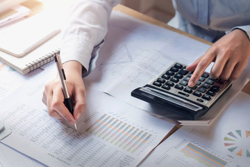 Fototapete - finance and accounting concept. business woman working on desk using calculator to calculate in office