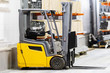 Forklift truck Stock. Logistics. Sending goods. Storage. Transportation of goods. Carton boxes. Storage equipment. Yellow forklift stands at the rack