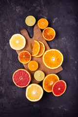 Sticker - Various types of citrus fruit cut into slices on a dark background