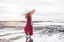 Elegant Lady In Straw Hat And Red Dress On Beach