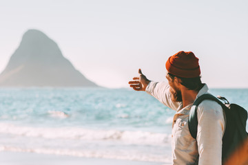 Man traveler showing rock in the ocean enjoying landscape travel healthy lifestyle adventure summer vacations in Norway active trip outdoor