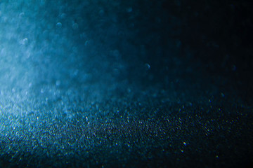 Bokeh defocused glittering lights blurred abstract blue black dark background