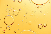 Beautiful Macro Photo Of Water Droplets In Oil With A Yellow Background.
