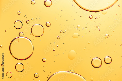 Fotografía Beautiful macro photo of water droplets in oil with a yellow background