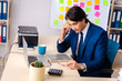 © Elnur - Young businessman working in the office