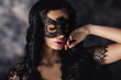 portrait of sexy beautiful woman in lace black erotic lingerie and carnival mask on dark background
