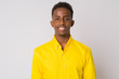 Happy young African businessman with yellow shirt smiling