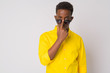 Young African businessman with yellow shirt peeking through sunglasses