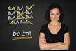 © VaLDIVIA - Junger Frau mit verschränkten Armen, 'bla bla bla ... do it' Text auf einem Tafelhintergrund
