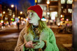 Smartphone beleuchtet Gesicht eines Mädchens nachts in der Stadt