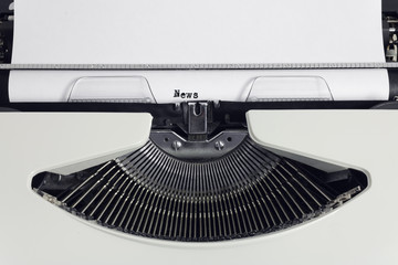 Fototapete - Old retro obsolete white typewriter with close-up typing text News as heading on paper