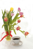 Fototapeta Tulipany - cup of coffee and a bouquet of flowers on a white background, a beautiful morning and the arrival of spring