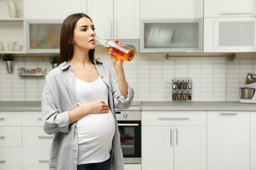 Poster - Future mother drinking alcohol in kitchen. Bad habits during pregnancy